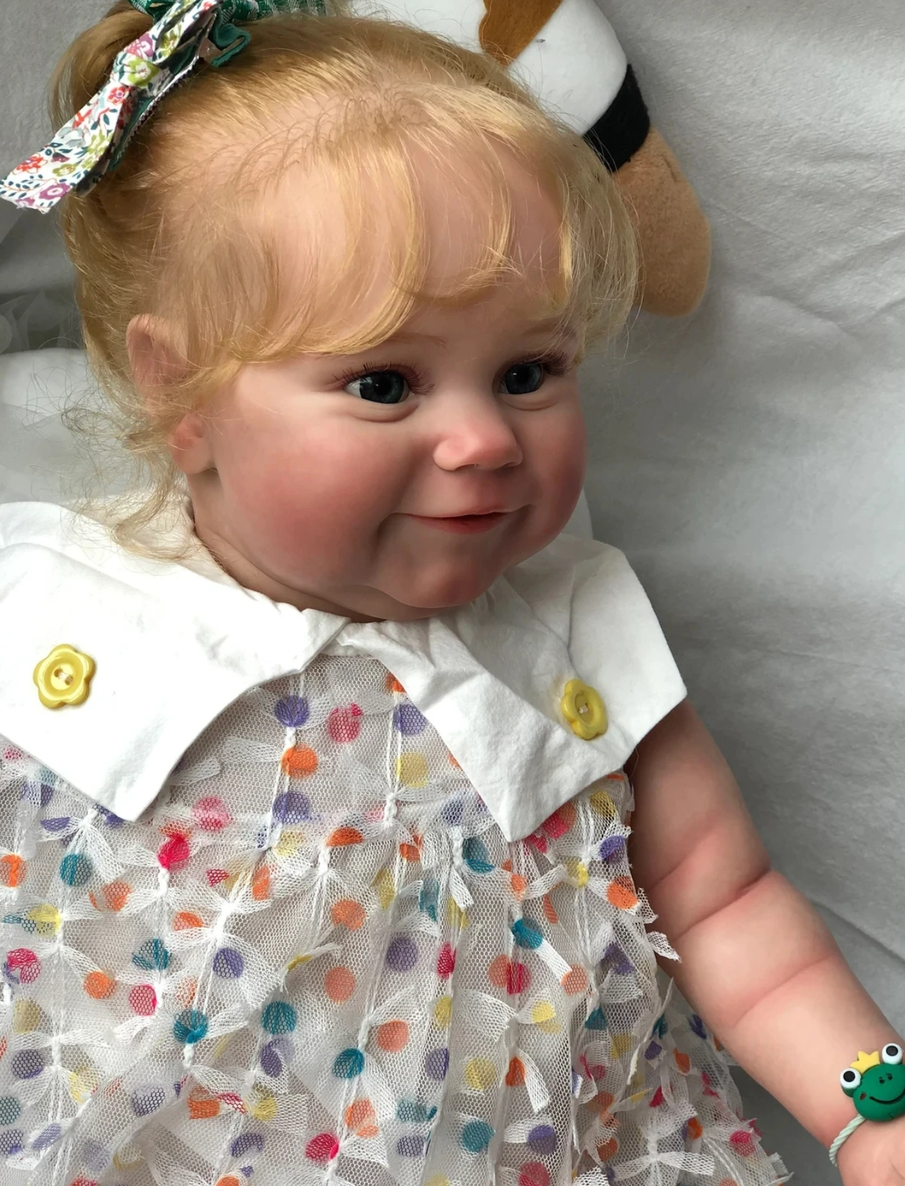 Charlotte babydukke med langt lyst krøllet hår